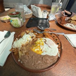 Chilaquiles, eggs and beans with side of chicharron in sauce. Chilaquiles, eggs and beans with side of chicharron in sauce.
