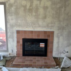 ProFix Services - New tile was then installed, and the project was completed with the installation of a glass fireplace door.
