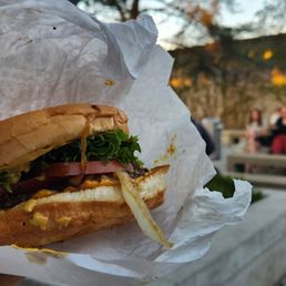 Cheeseburger with lettuce, tomatoes, pickles, onions, ketchup, mustard. Cheeseburger with lettuce, tomatoes, pickles, onions, ketchup, mustard.
