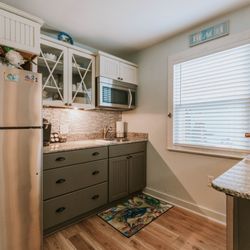 Front Beach Cottages - Bellande's kitchen includes stovetop, dishwasher, microwave, full size refrigerator. It is also stock with plenty of dishes and cookware.
