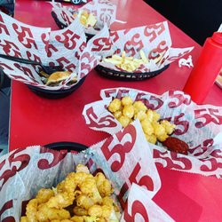 Hwy 55 Burgers Shakes & Fries - Shrimp Po Boy, Jalapeño Cheesesteak, and Cheeseburger with fries and tots.