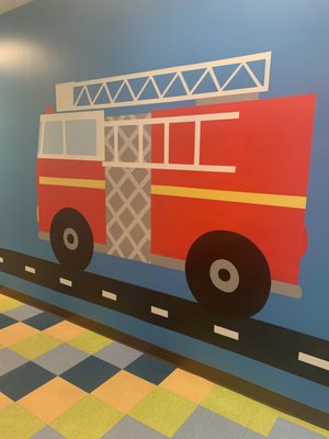 It takes a Village - At ABC Behavior Therapy, I wanted to give their massive hallway as MANY learning opportunities as I possibly could. And to fit their theme of "it takes a village to raise a child," I gave them a little village. This gives their kids and therapists plenty of opportunities to identify shapes, colors, letters, numbers, toys, clothes, foods, community signs, buildings, safety signs and so much more. It takes a Village - At ABC Behavior Therapy, I wanted to give their massive hallway as MANY learning opportunities as I possibly could. And to fit their theme of "it takes a village to raise a child," I gave them a little village. This gives their kids and therapists plenty of opportunities to identify shapes, colors, letters, numbers, toys, clothes, foods, community signs, buildings, safety signs and so much more.