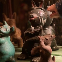 A unique hand-made clay dog with red ears holding a puppy. made in Mexico. A unique hand-made clay dog with red ears holding a puppy. made in Mexico.