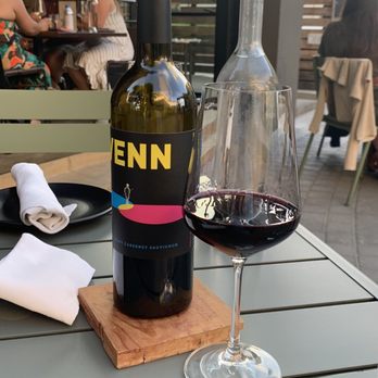 Compline Restaurant - Outdoor seating with a bottle of Venn. - Wine Bars Near Me - Napa, California