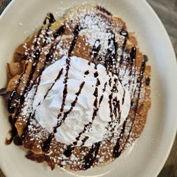 Bacon, chocolate chip pancakes with chocolate syrup and whipped cream Bacon, chocolate chip pancakes with chocolate syrup and whipped cream
