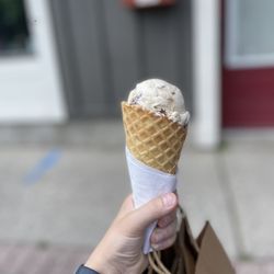 What's the Scoop - One scoop of ice cream in a waffle cone.
