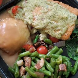 Pesto salmon ontop of spinach and tomatos with green beans and mash