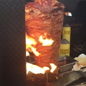 Tacos Los Olivos - a large meat being cooked on a grill - Tacos Near Me - Beaumont, California Tacos Los Olivos - a large meat being cooked on a grill - Tacos Near Me - Beaumont, California