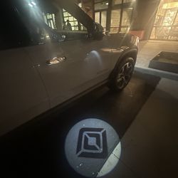 Rivian - Logoed Rivian gobo on each front door.