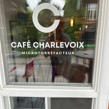 Café Charlevoix - a woman taking a picture through a window - Coffee & Tea Near Me - Baie-Saint-Paul, Quebec Café Charlevoix - a woman taking a picture through a window - Coffee & Tea Near Me - Baie-Saint-Paul, Quebec