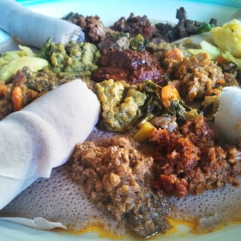 Sunset Cafe - A sampler plate of meat and veggie dishes with injera, traditional Ethiopian flat bread. - Ethiopian Near Me - Seattle, Washington