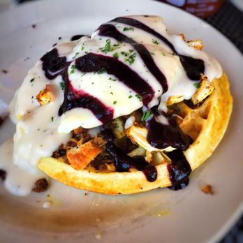 School House Kitchen & Libations - An excellent dish. Flavorful chicken on top of a large waffle covered in a delicious gravy and grape preserve. - New American Near Me - Arvada, Colorado School House Kitchen & Libations - An excellent dish. Flavorful chicken on top of a large waffle covered in a delicious gravy and grape preserve. - New American Near Me - Arvada, Colorado