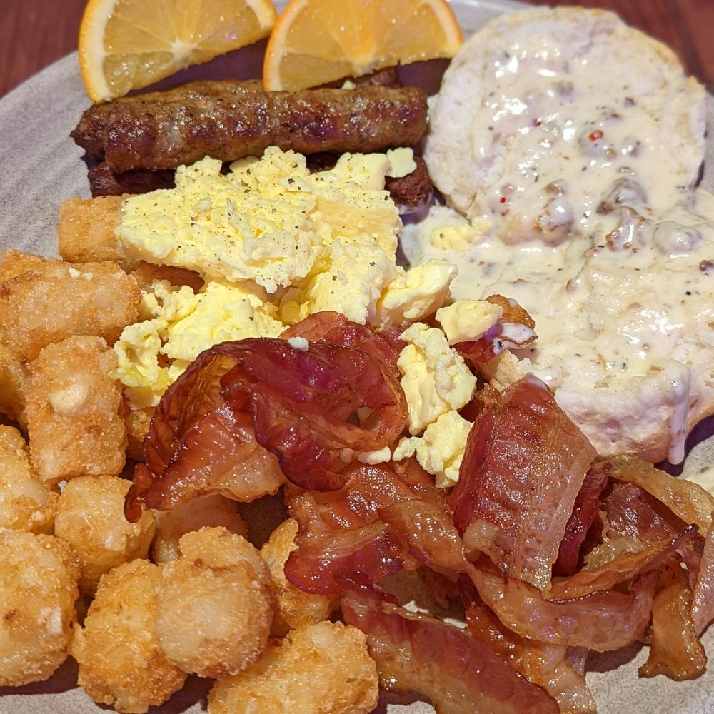 Dragon's Den - Breakfast buffet: tater tots, bacon, sausage, eggs, biscuits and gravy, and oranges. - American Near Me - Carlsbad, California