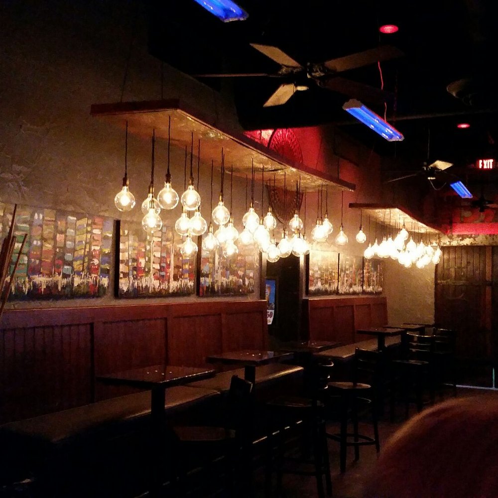 people sitting at tables in a dimly lit bar people sitting at tables in a dimly lit bar