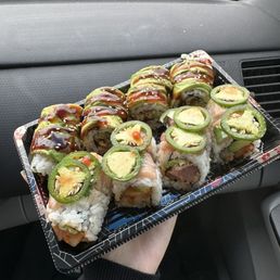 a person holding a tray of sushi a person holding a tray of sushi