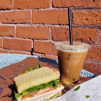 Wild Roots - Montague sandwich on Gluten free bread, with a nitro cold brew with almond milk. Sitting on their outdoor patio table - Juice Bars & Smoothies Near Me - Sunderland, Massachusetts