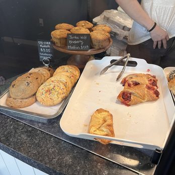 Molly's Bakery - Cookies, muffins, and pastries are arranged on trays and a stand at Molly's Bakery, with handwritten labels and prices. - Bakeries Near Me - Beacon Falls, Connecticut