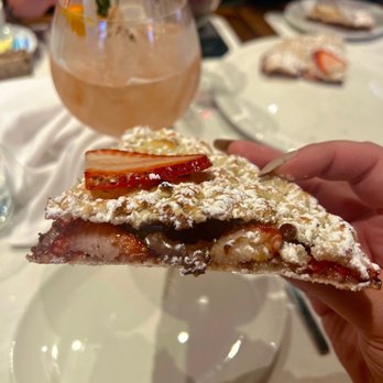 Serafina - Madison 38th - a hand holding a piece of pizza - Italian Near Me - New York, New York Serafina - Madison 38th - a hand holding a piece of pizza - Italian Near Me - New York, New York