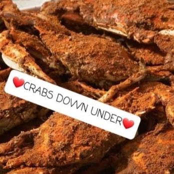 Crabs Down Under - A pile of seasoned crabs with a spice coating, accompanied by a caption reading 'CRABS DOWN UNDER' with heart emojis. - Seafood Near Me - Baltimore, Maryland