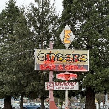 The Embers - A neon sign for The Embers Bar & Grill features the restaurant's name, a phone icon, and a breakfast offering, set against trees and a parking lot. - Salad Near Me - Eugene, Oregon