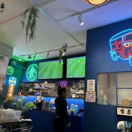 a woman standing in front of a neon sign a woman standing in front of a neon sign