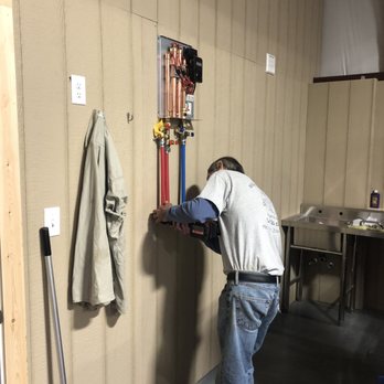 Millard Plumbing - a man fixing a water heater - Plumbing Near Me - Dardanelle, Arkansas Millard Plumbing - a man fixing a water heater - Plumbing Near Me - Dardanelle, Arkansas
