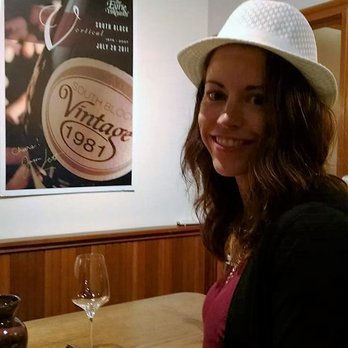 Eyrie Vineyards - a woman sitting at a table with a glass of wine - Wineries Near Me - McMinnville, Oregon