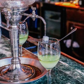 Old Absinthe House - a glass of green liquid with a spoon in it - Dive Bars Near Me - New Orleans, Louisiana
