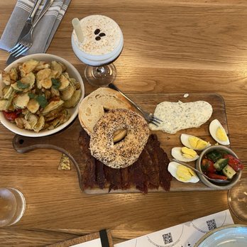 Sixty Vines - Brunch Board: candied bacon, tomato-cucumber salad, hard boiled eggs, dill-chive cream cheese, toasted everything bagel - New American Near Me - Charlotte, North Carolina