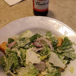 a salad and a bottle of pizzeria