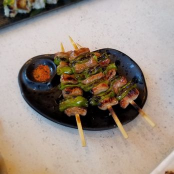 Robata Wasa - Pork with Shishito Pepper Robata. Dragon Roll in the back. - Sushi Bars Near Me - Irvine, California Robata Wasa - Pork with Shishito Pepper Robata. Dragon Roll in the back. - Sushi Bars Near Me - Irvine, California