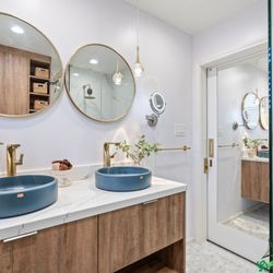 Green Bay Remodeling - Bathroom Remodel with elegant gold-accented twin mirror and vessel sink, glass panel for shower area