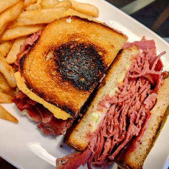 Bode's Corned Beef House - Grilled corned beef sandwich with Swiss cheese and slaw, with (added) French fries. - American Near Me - Plymouth, Michigan