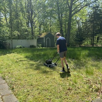 Man Mowing - Working hard on a client's lawn - Lawn Services Near Me