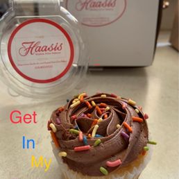 Scrumptious vanilla cupcake with creamy chocolate icing and rainbow jimmies.