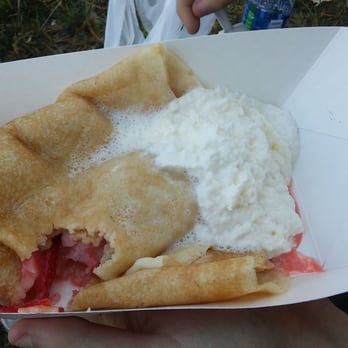 Crepe Cottage - a person holding a container of food - Creperies Near Me