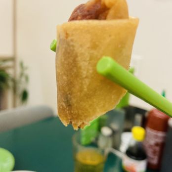 Pho Nhuan - a piece of food being held by a pair of chopsticks - Vietnamese Near Me - Vancouver, British Columbia