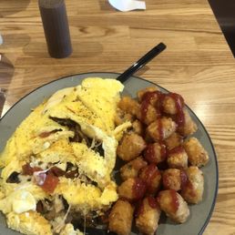 Omelet with mushrooms and tomato, with tots. Omelet with mushrooms and tomato, with tots.