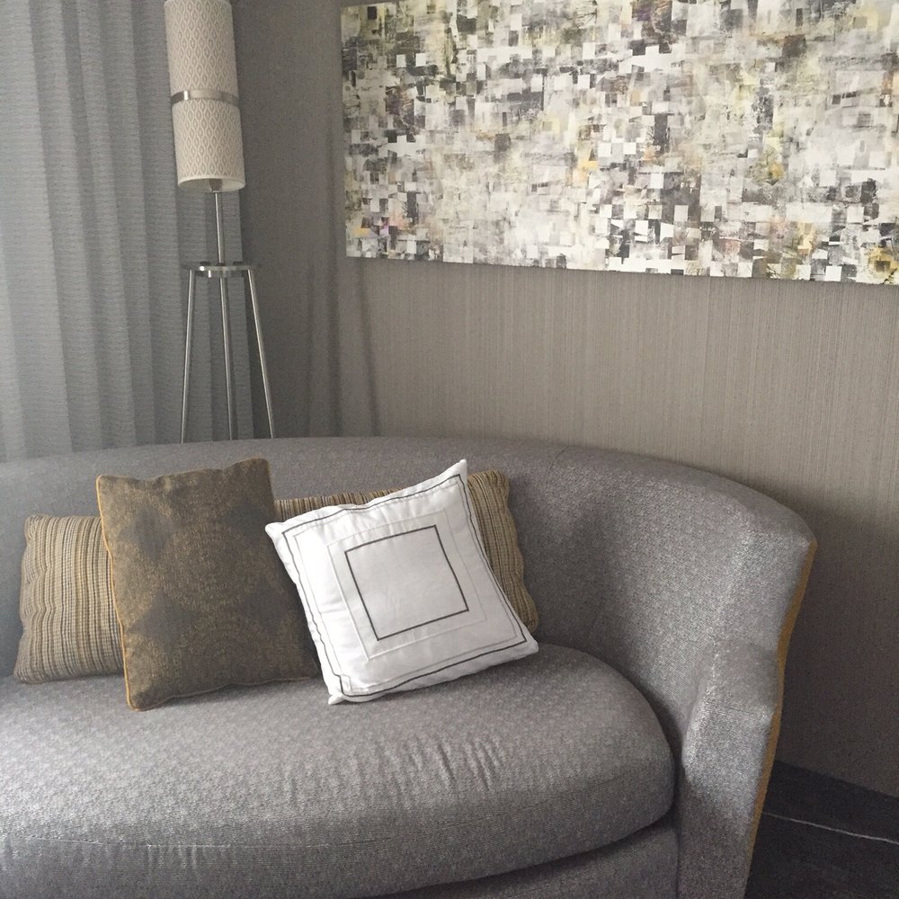 Little sofa inside a room with a king bed.