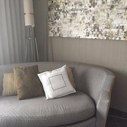 Little sofa inside a room with a king bed.