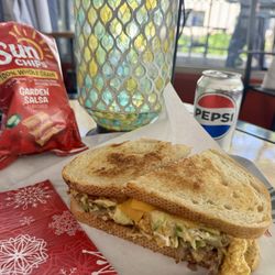 Downtown Oak - Breakfast Sandwich: scrambled eggs, bacon, hashbrowns, cheese, peppers, onions, and mushrooms on toasted sourdough.