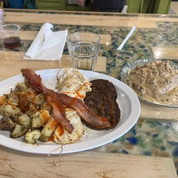 Baked Bistro - Fried eggs, bacon, sausage patty, smashed potatoes, and sausage gravy on a biscuit. - New American Near Me - Hampton, Virginia Baked Bistro - Fried eggs, bacon, sausage patty, smashed potatoes, and sausage gravy on a biscuit. - New American Near Me - Hampton, Virginia