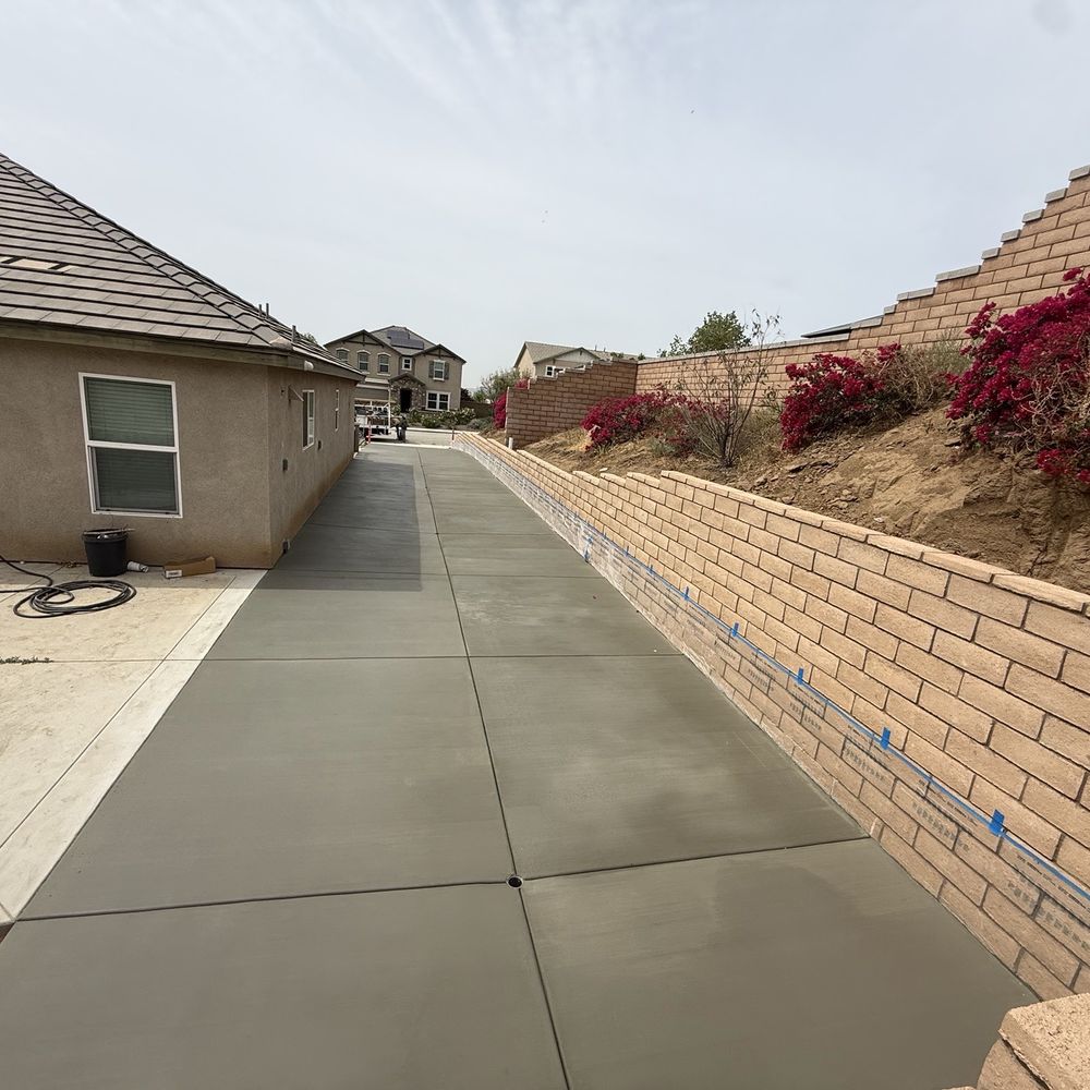 Dreamscapes & Construction Services - Useful side yard with retaining wall and cement. - Masonry/Concrete Near Me