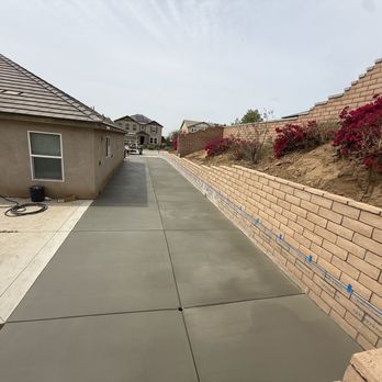 Dreamscapes & Construction Services - Useful side yard with retaining wall and cement. - Masonry/Concrete Near Me