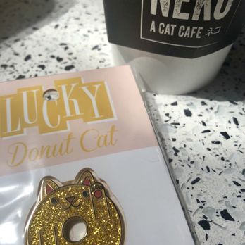 NEKO: A Cat Cafe - A gold lucky donut cat pin - Themed Cafes Near Me - Seattle, Washington