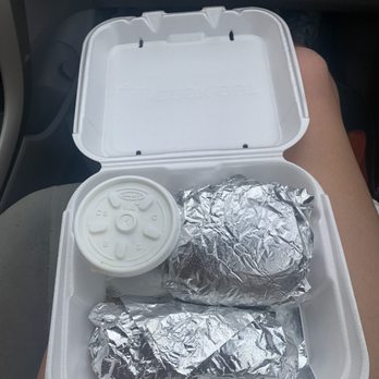 Cook Out - a lunch in a styrofoam container - Foil-wrapped food items and a drink in a foam takeout container, held on a person's lap inside a vehicle. - Burgers Near Me - Williamsburg, Kentucky