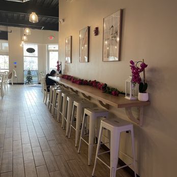 Hellenic Greek Kitchen - a long table with white stools - Greek Near Me - Charlotte, North Carolina Hellenic Greek Kitchen - a long table with white stools - Greek Near Me - Charlotte, North Carolina