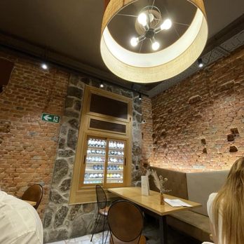 Sidreria La Poasada - Cozy corner sitting, chilled wine in backdrop - Spanish Near Me Sidreria La Poasada - Cozy corner sitting, chilled wine in backdrop - Spanish Near Me