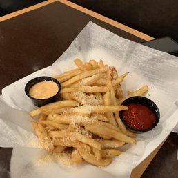 a basket of french fries and dipping sauce