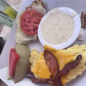 Dune Deck's Mimosa Cafe - Croissant Egg Sandwich with bacon and a side of grits - Breakfast & Brunch Near Me - Boynton Beach, Florida Dune Deck's Mimosa Cafe - Croissant Egg Sandwich with bacon and a side of grits - Breakfast & Brunch Near Me - Boynton Beach, Florida